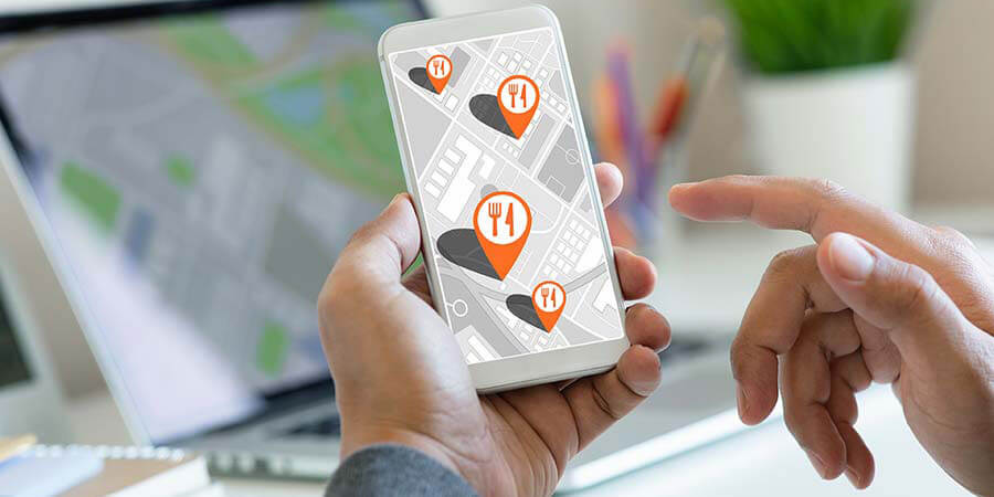 Man Holding Smartphone Displaying Restaurant Symbols 900x450